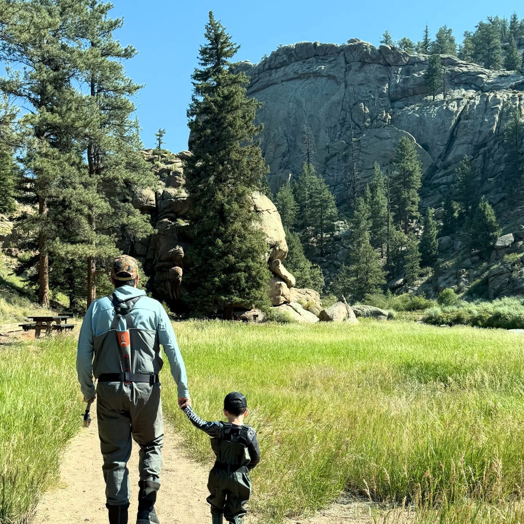 A father and his young son walking hand in hand up the trail into Eleven Mile Canyon on the way to the water